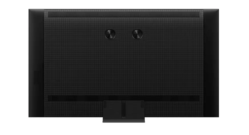 Parte trasera de un televisor negro con patrón de rejilla y dos botones circulares.