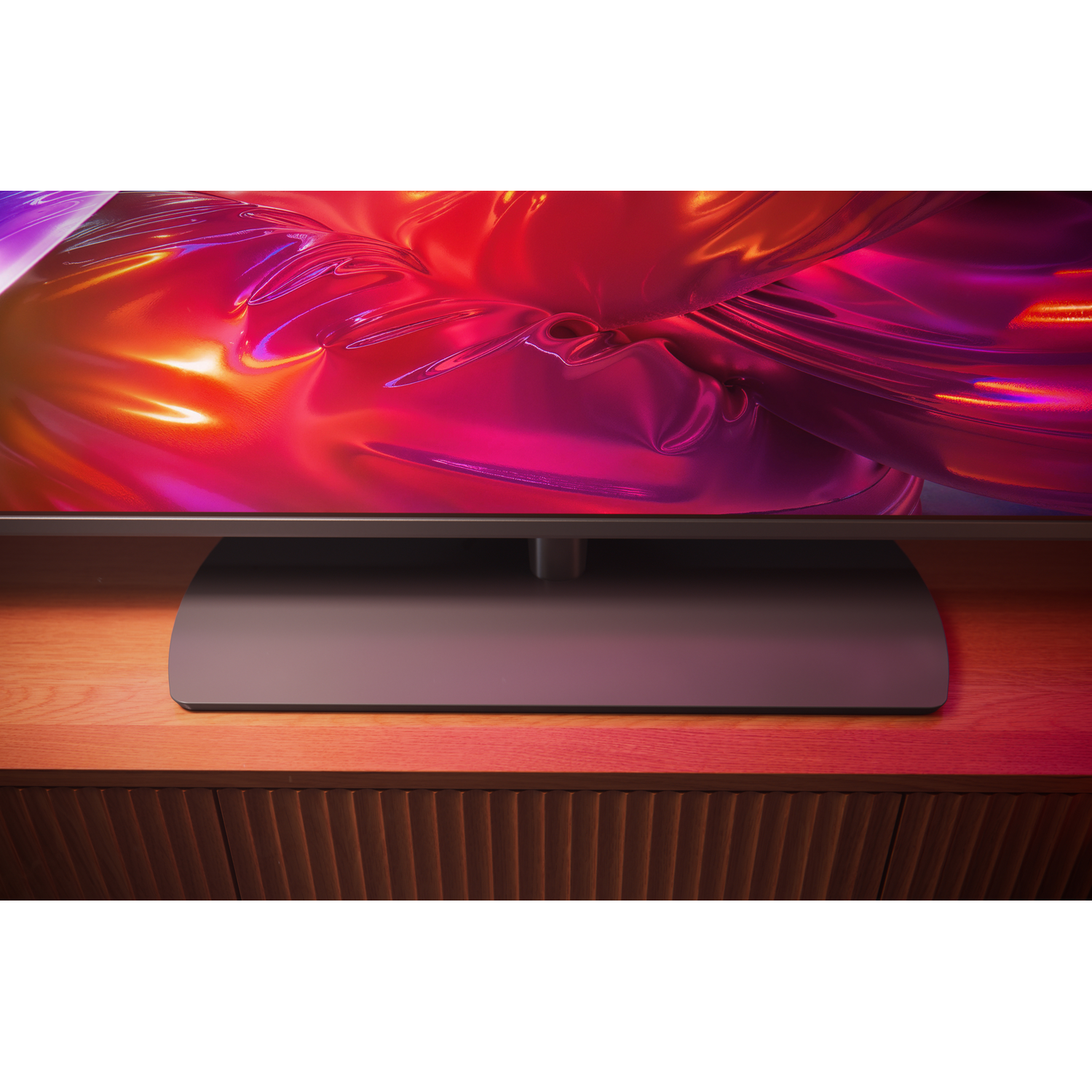A modern TV with an abstract, flowing background on a wooden cabinet.