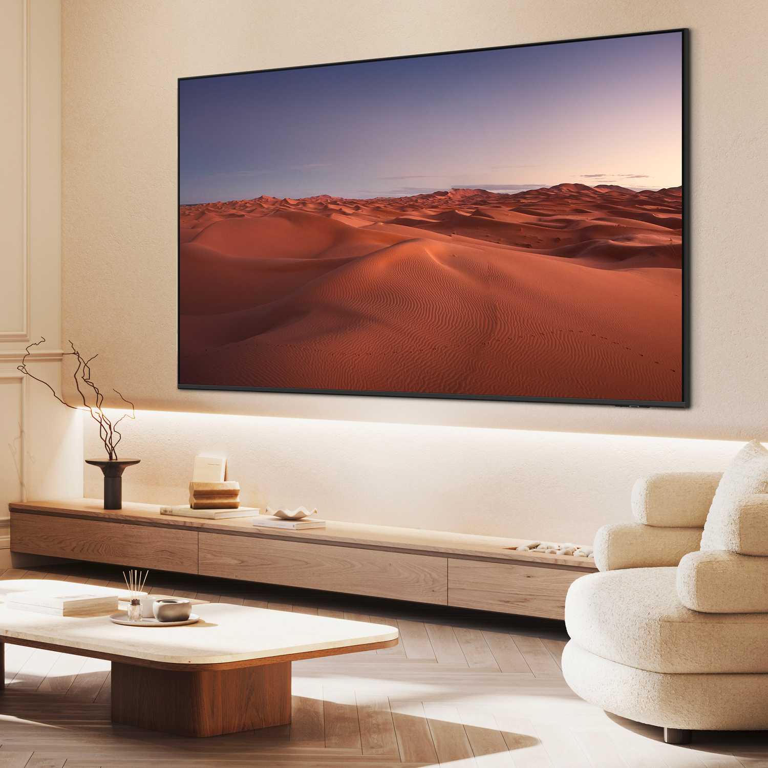 Un paesaggio desertico con dune di sabbia e cielo al tramonto su un grande schermo TV.