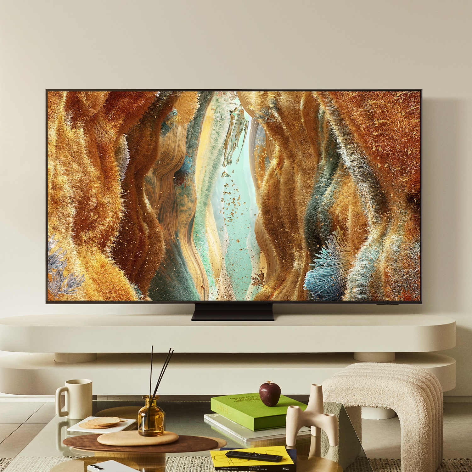 Un grande TV mostra arte astratta con sfumature marroni e blu, posizionato su un supporto sopra un tavolino di vetro.