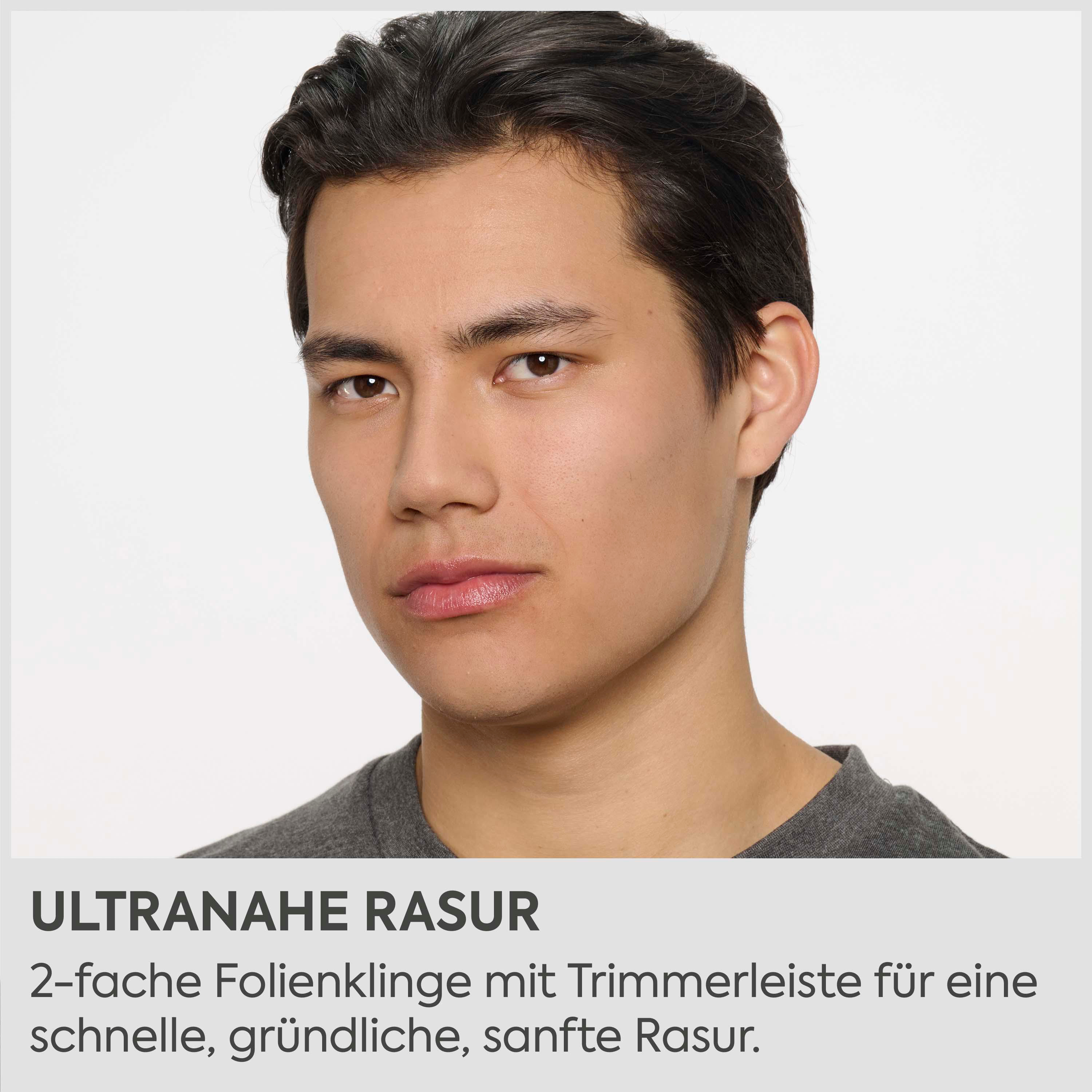 Ein Mann mit dunklem Haar blickt nach vorne. Er trägt ein graues T-Shirt.