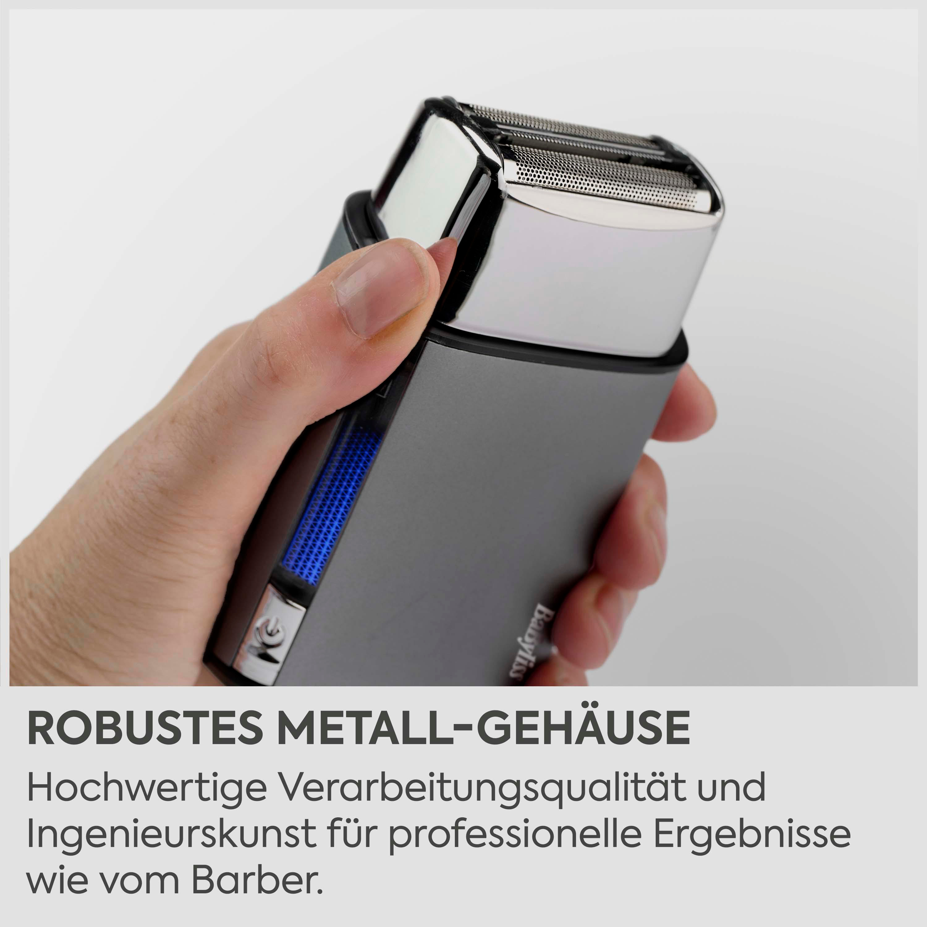 Eine Hand hält einen silbernen und grauen Elektrorasierer mit doppeltem Scherkopf.