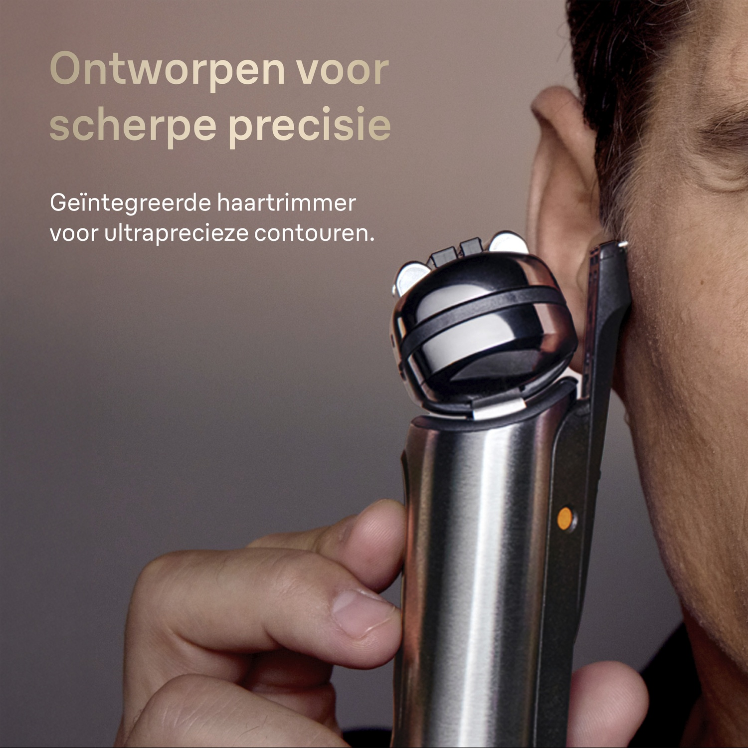 A man uses a precision trimmer near his ear. Metallic body.