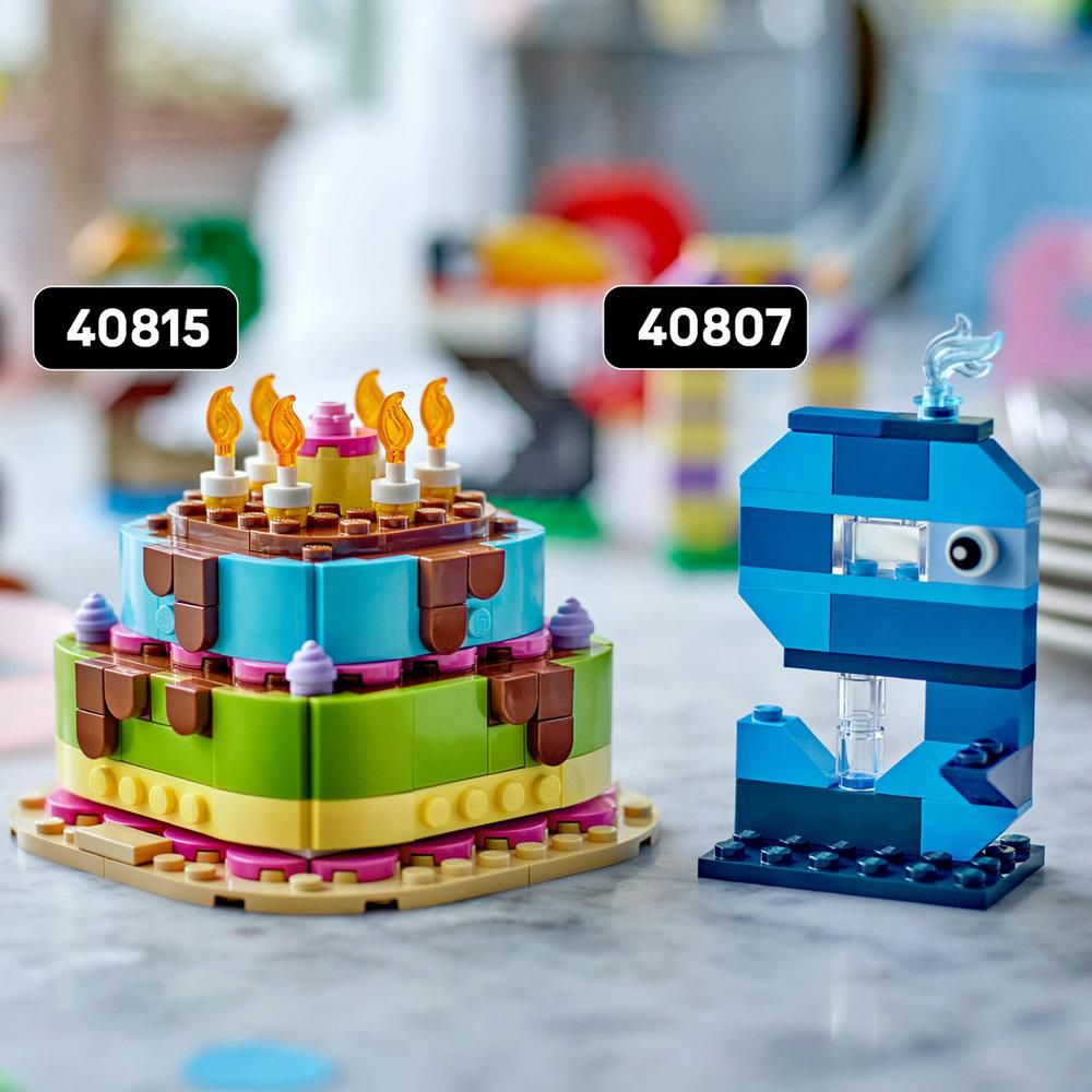 Zwei Lego-Modelle: eine bunte Torte mit Kerzen und eine blaue abstrakte Form.