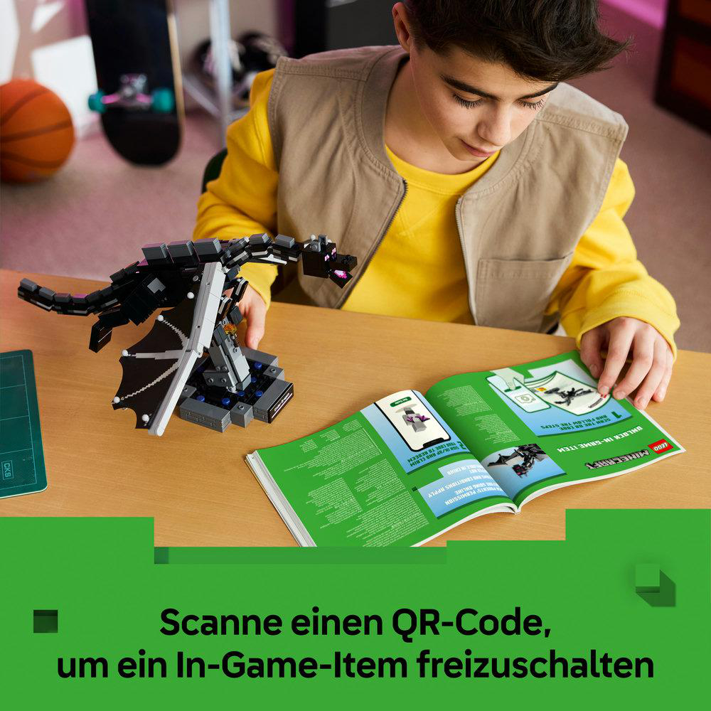 Ein Junge baut ein Lego Minecraft Drachenmodell und schaut auf ein Buch.