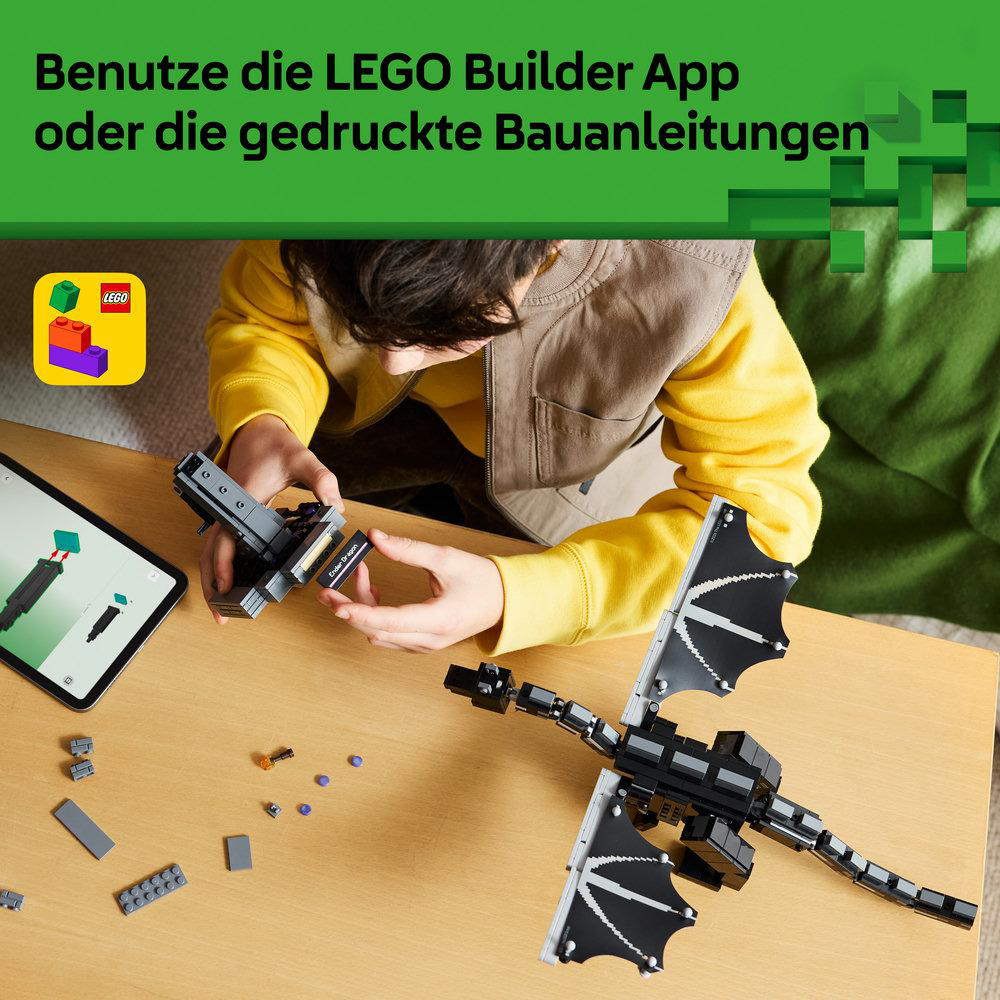 Kind baut mit Lego einen Drachen. Auf dem Tisch liegen Bausteine und ein Tablet.