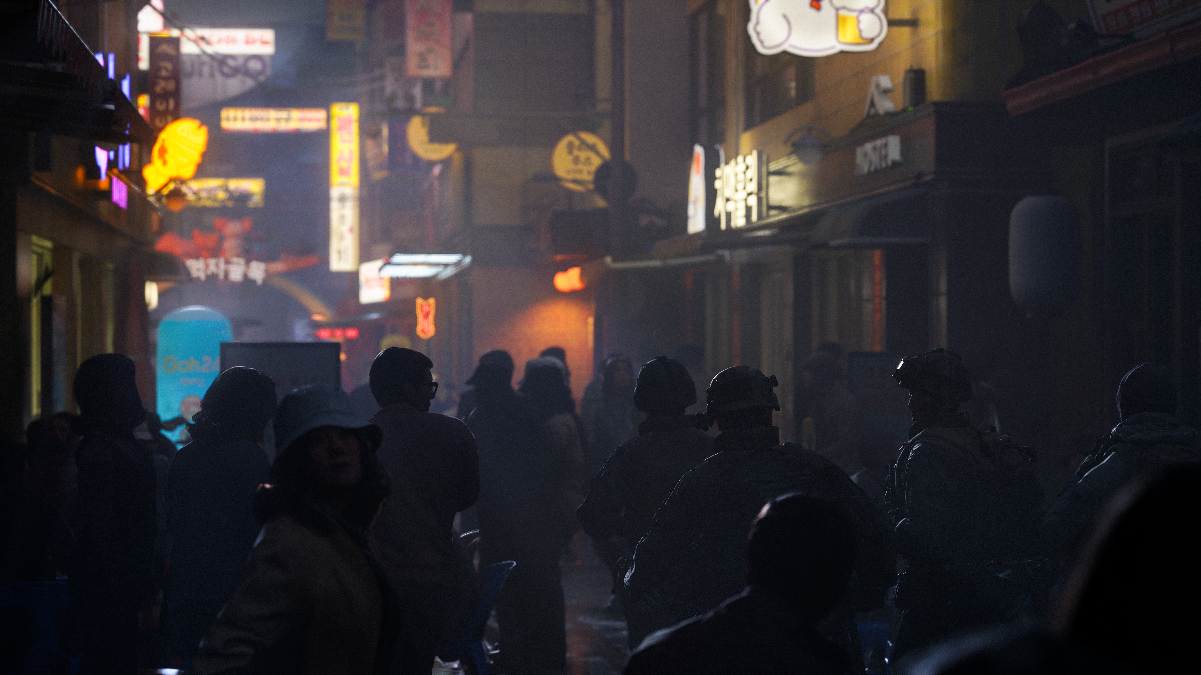 Nachtszene einer belebten Gasse mit Neonlichtern und vielen Menschen.