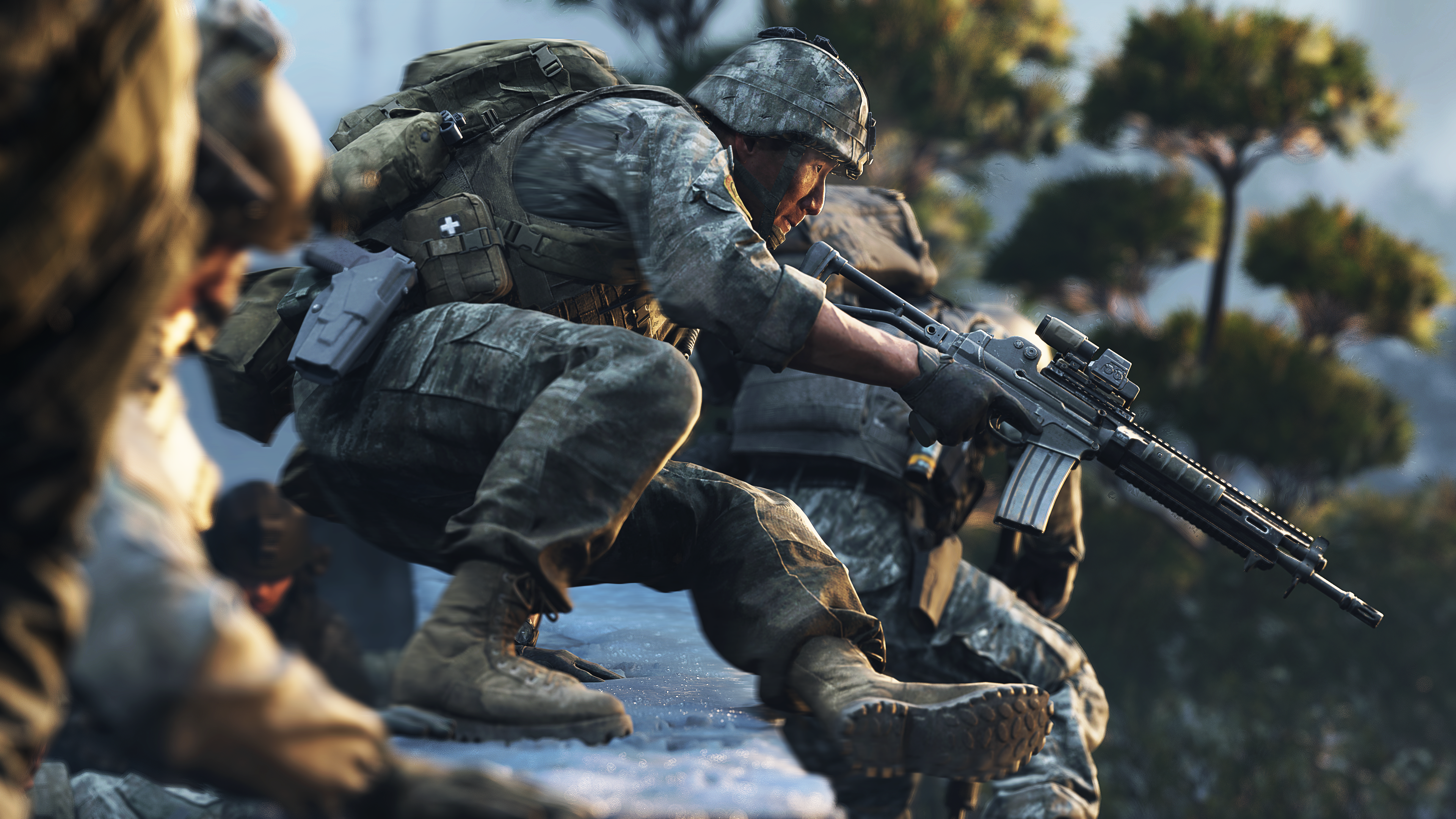 Soldat in Tarnkleidung mit Gewehr kauert auf Felsvorsprung mit Bäumen im Hintergrund.