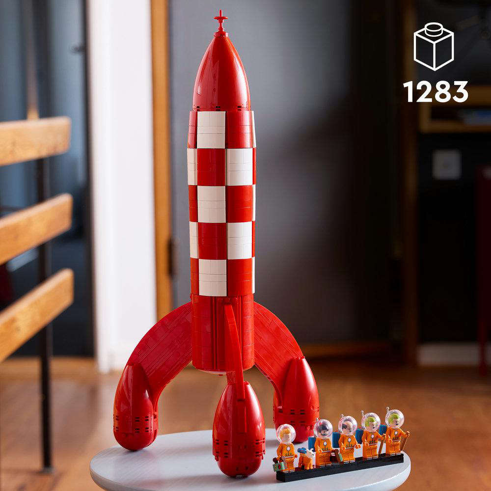 Rot-weißer Raketen-Baukasten mit Flügeln und fünf Astronauten in orangefarbenen Anzügen.