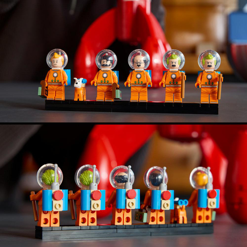 Sechs orange Lego-Astronauten und ein Hund stehen in zwei Reihen vor einem roten Raumschiff.