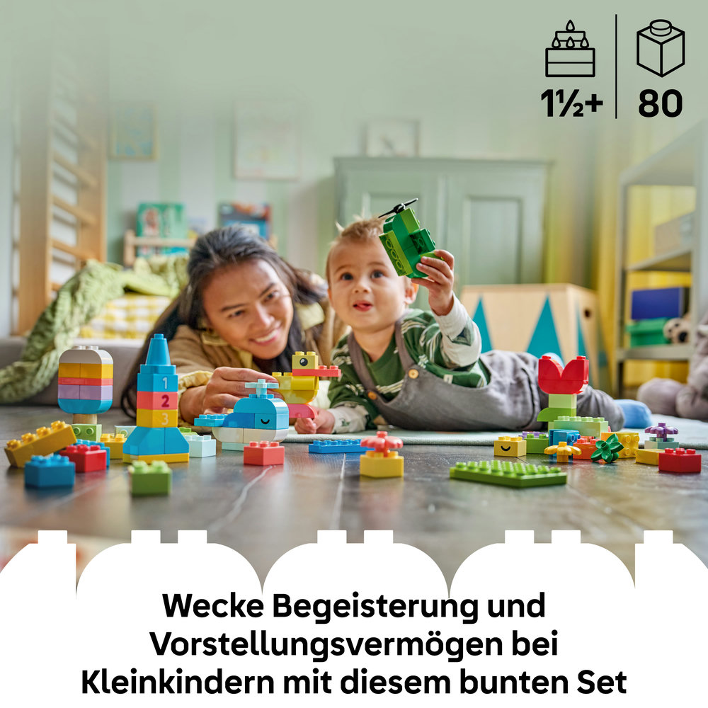 Frau und Kind spielen mit bunten Bausteinen, darunter ein Hubschrauber und eine Blume.