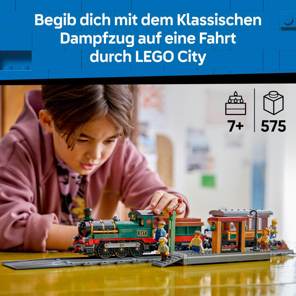 Ein Junge baut eine grüne LEGO-Eisenbahn mit Figuren am Bahnhof.