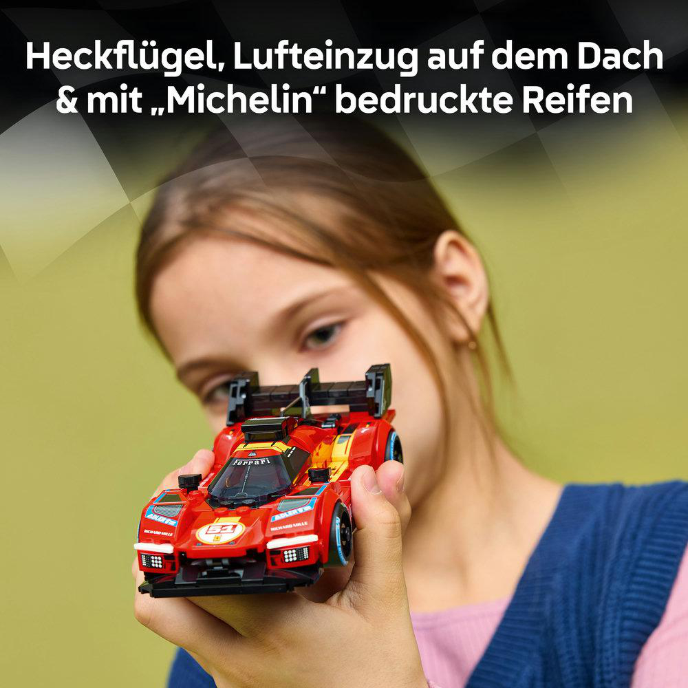 Kind hält roten Ferrari-Rennwagen-Spielzeugauto mit Flügel und Michelin-Reifen.