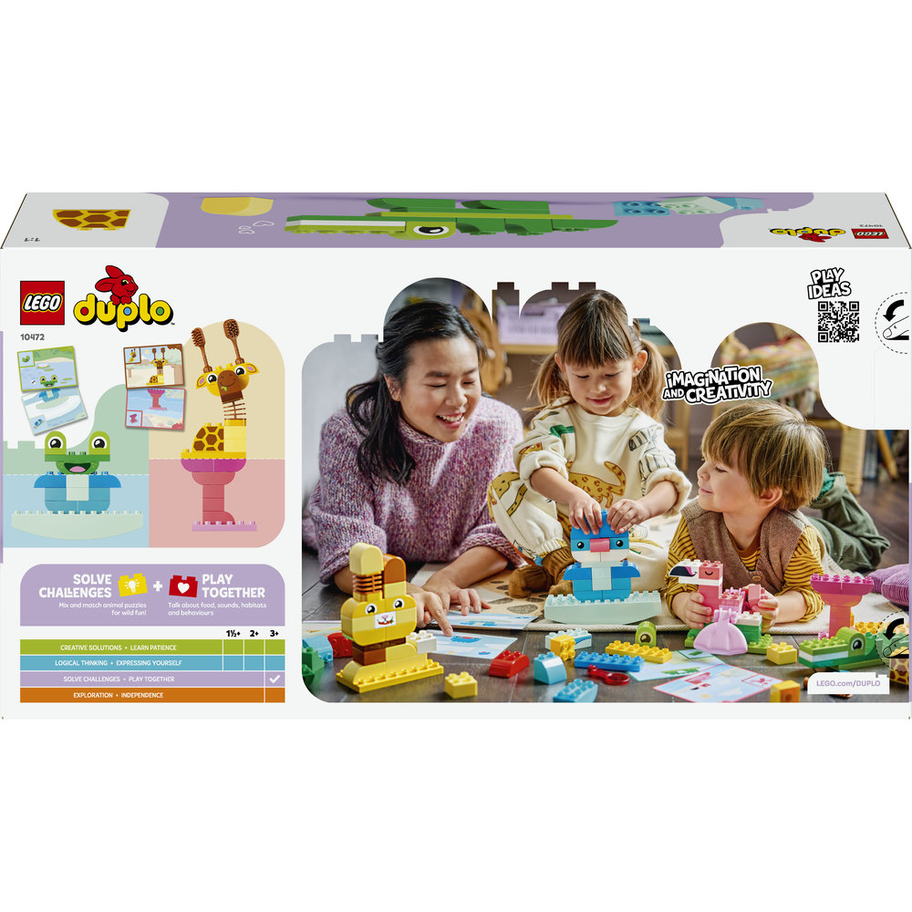 Eine Familie baut mit bunten LEGO Duplo Steinen auf dem Boden.