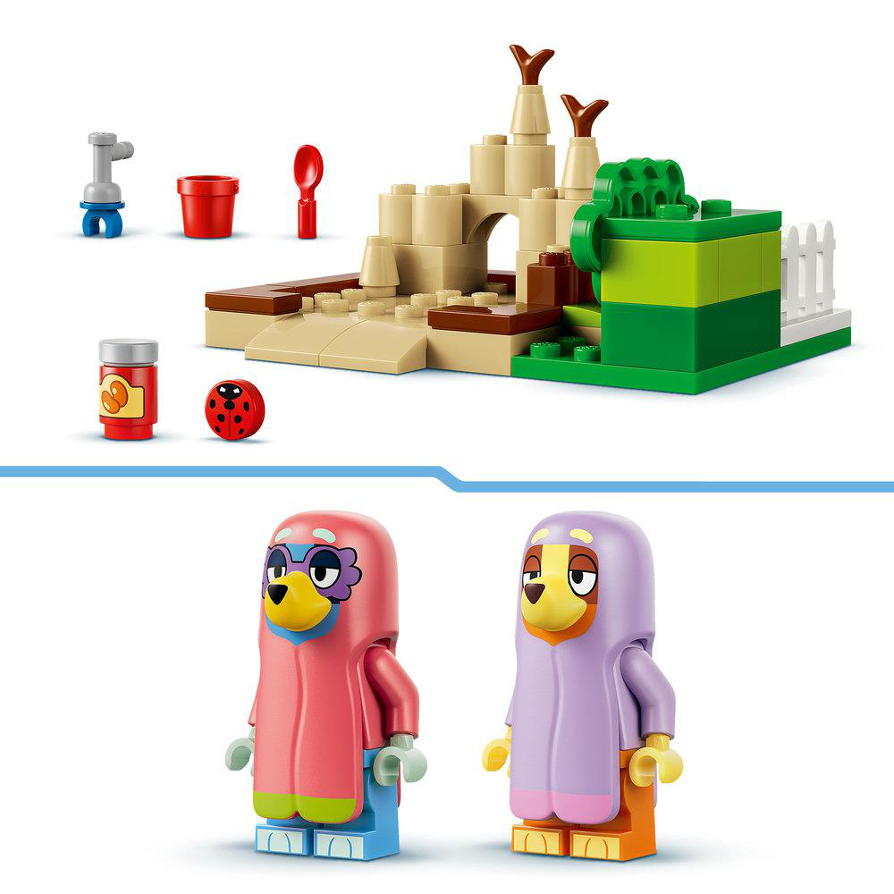Spielzeugburg mit Figuren, Eimer, Löffel, Ladybug und Dose.