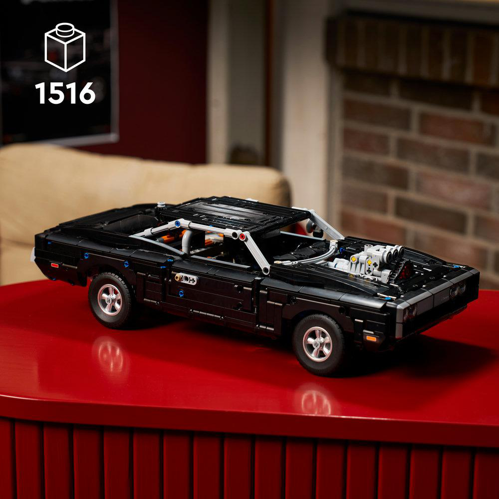 Schwarzes LEGO-Modell eines Dodge Charger mit geöffneter Motorhaube auf rotem Tisch.