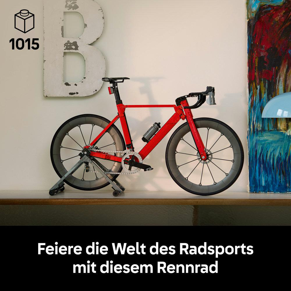 Ein rotes Rennrad aus Legosteinen steht auf einem Regal, daneben eine große Buchstaben-Deko.