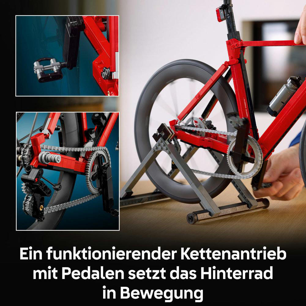 Ein rotes Lego-Fahrrad auf einem silbernen Ständer mit Kette und Pedalen.