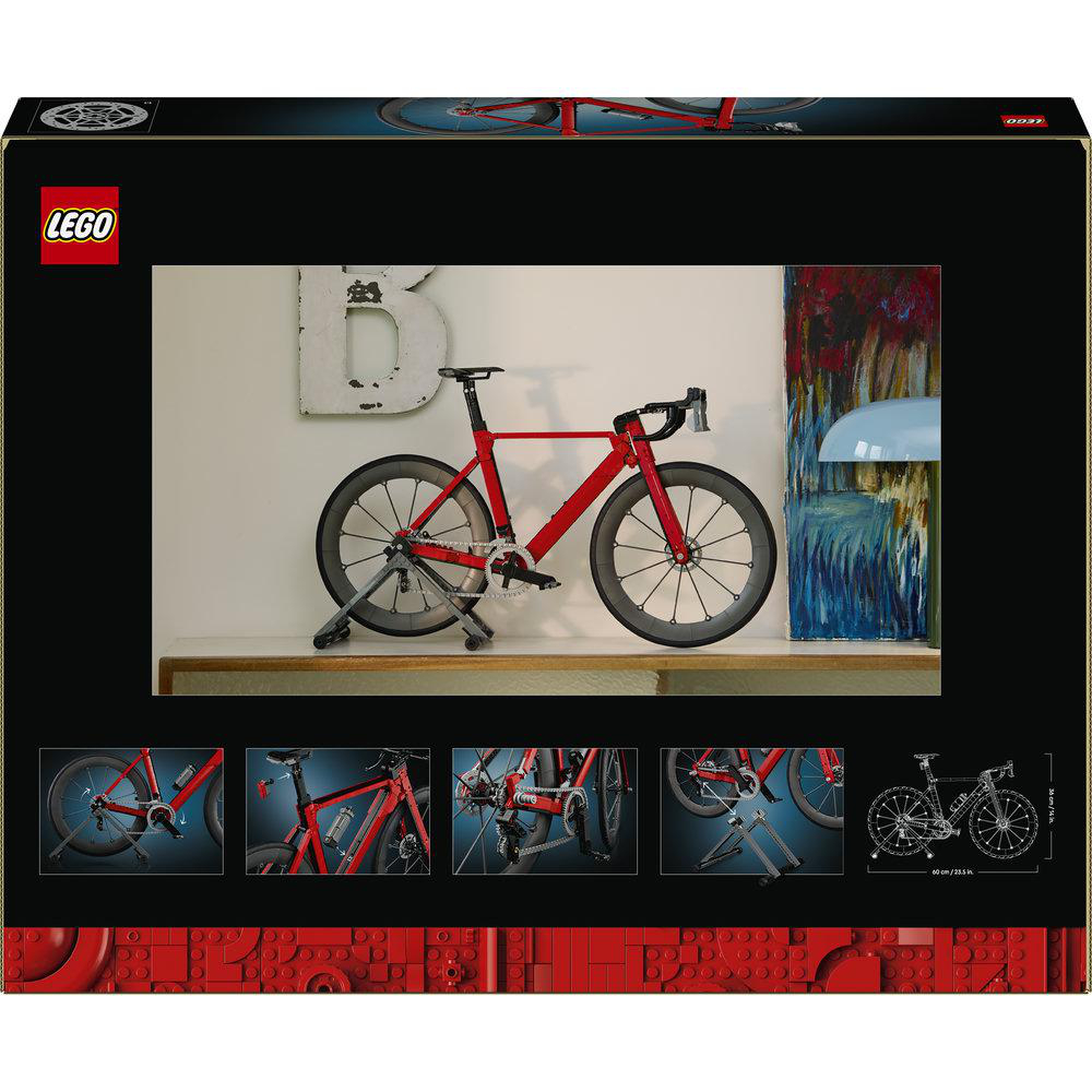 Ein rotes Rennrad auf einem Ständer vor einer Wand mit einer großen Deko-B.