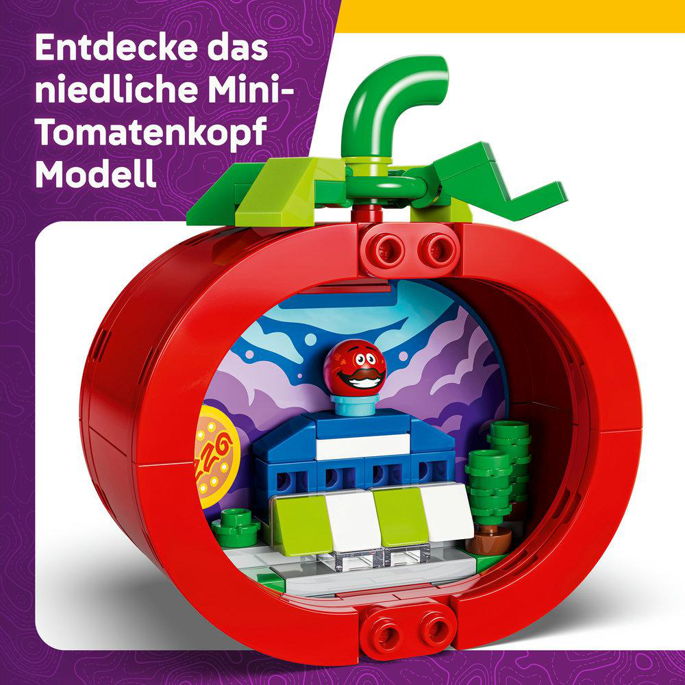 Ein rotes LEGO-Modell in Tomatenform mit einem lächelnden Gesicht. Es hat einen grünen Stiel und Blätter.