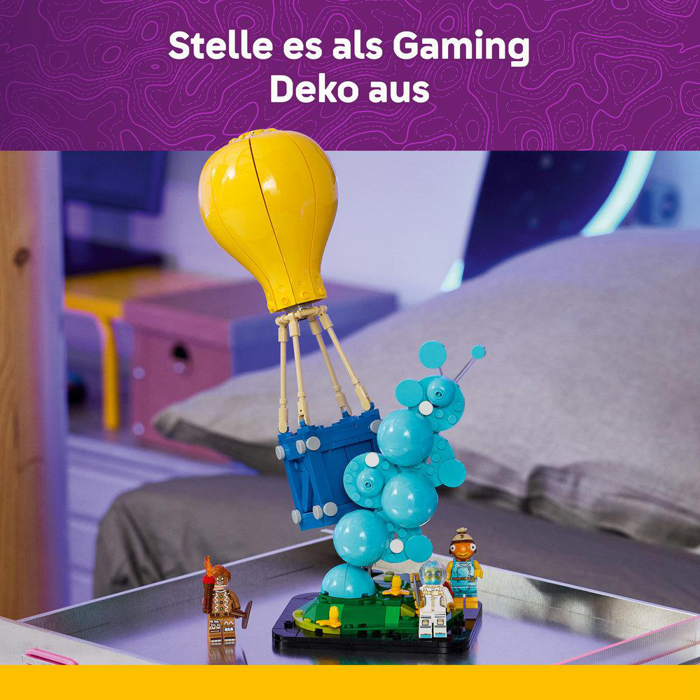 Ein gelber Ballon mit blauer Gondel schwebt über einer bunten Lego-Figur.