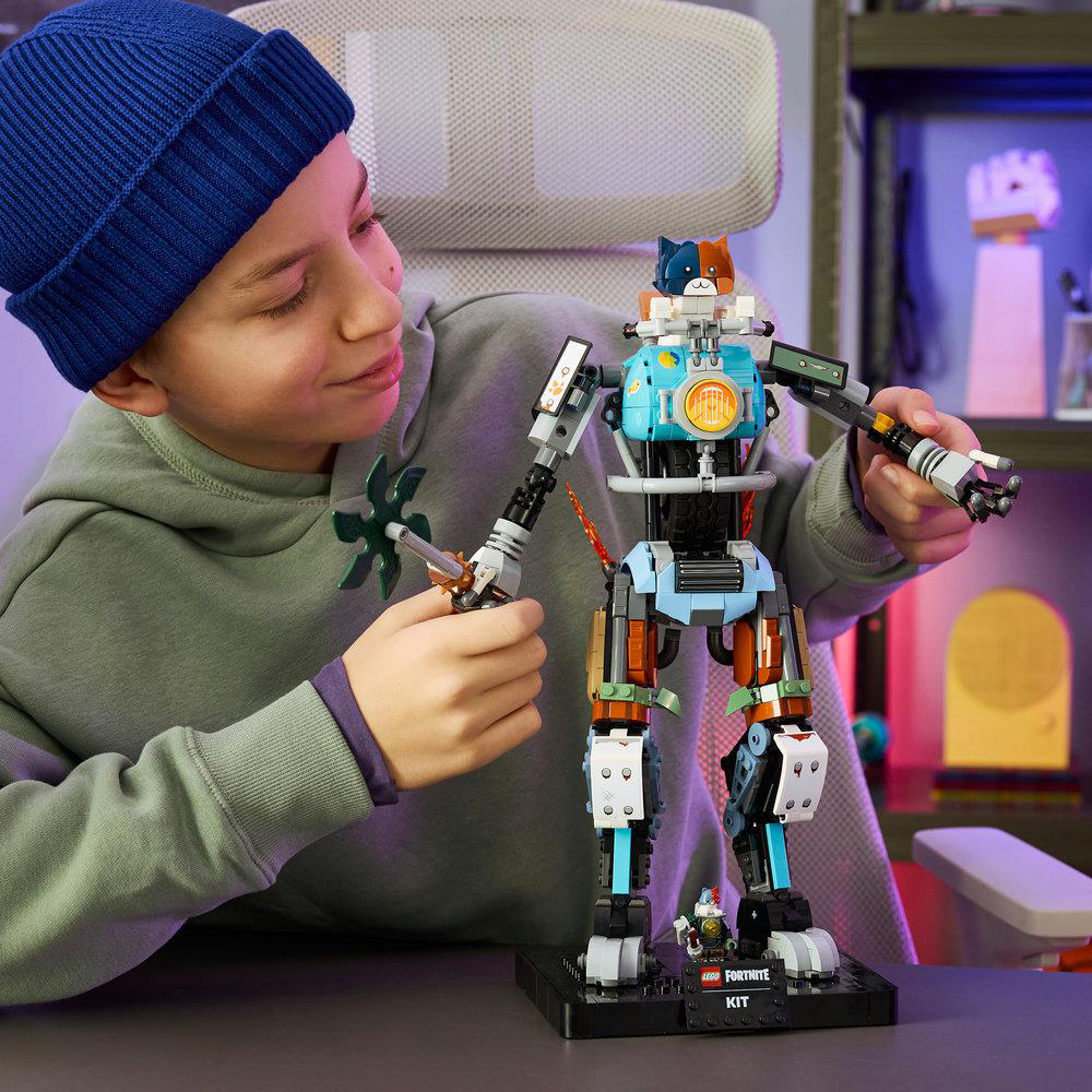 Ein Junge mit blauer Mütze baut einen bunten Lego-Roboter mit Katzenköpfen.