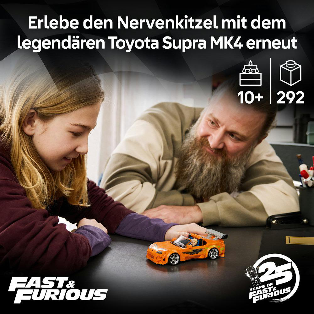 Ein Mann und ein Mädchen betrachten einen orangen Lego Toyota Supra.