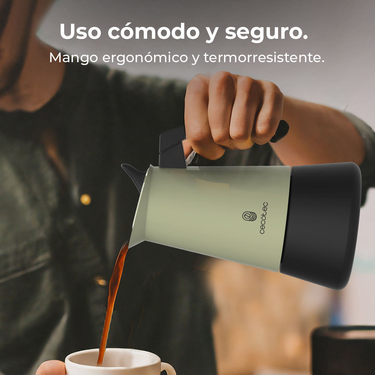 Una mano vierte café de una jarra verde claro en una taza blanca.