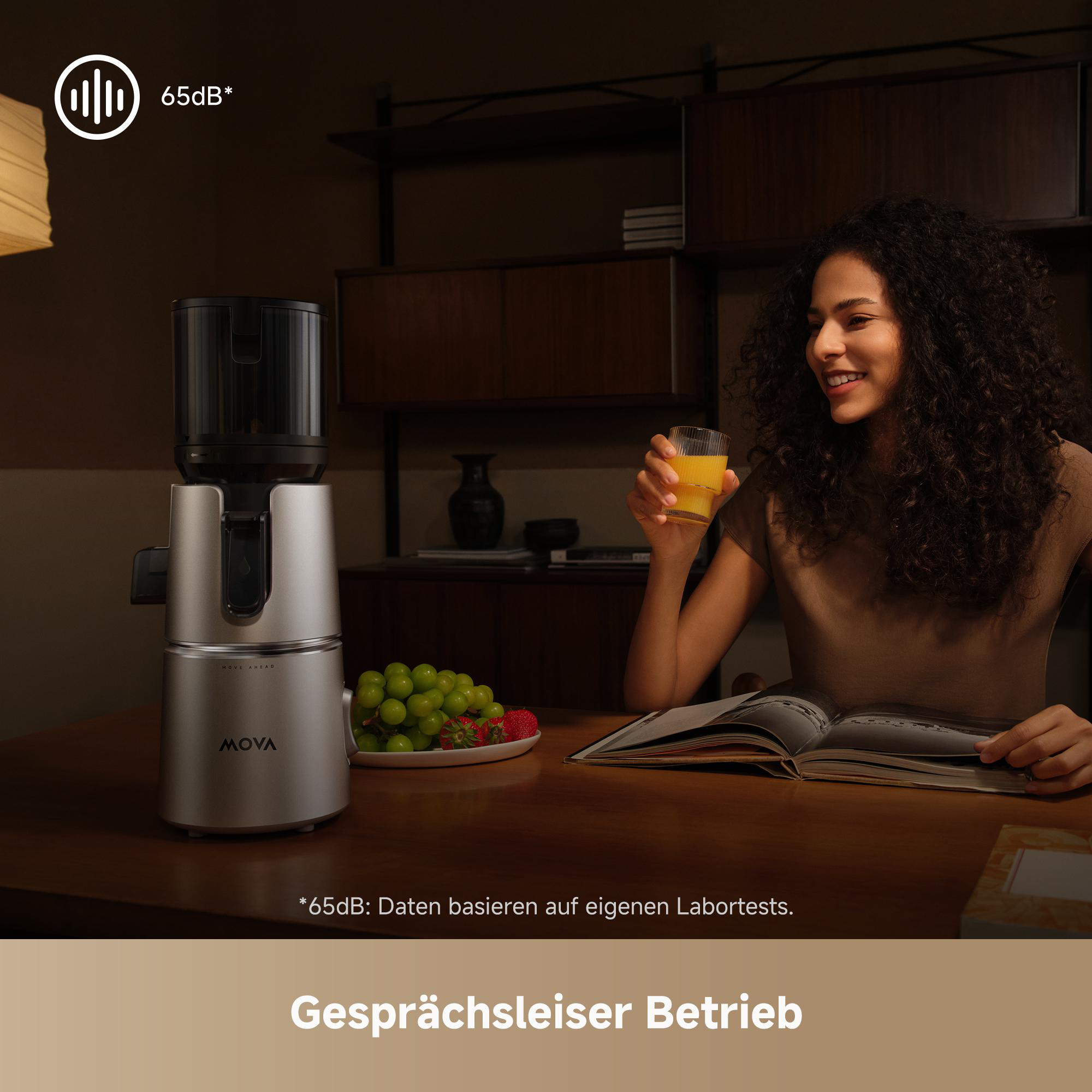Ein Entsafter steht auf einem Holztisch neben Obst, einer Frau mit Saft und einem Buch.