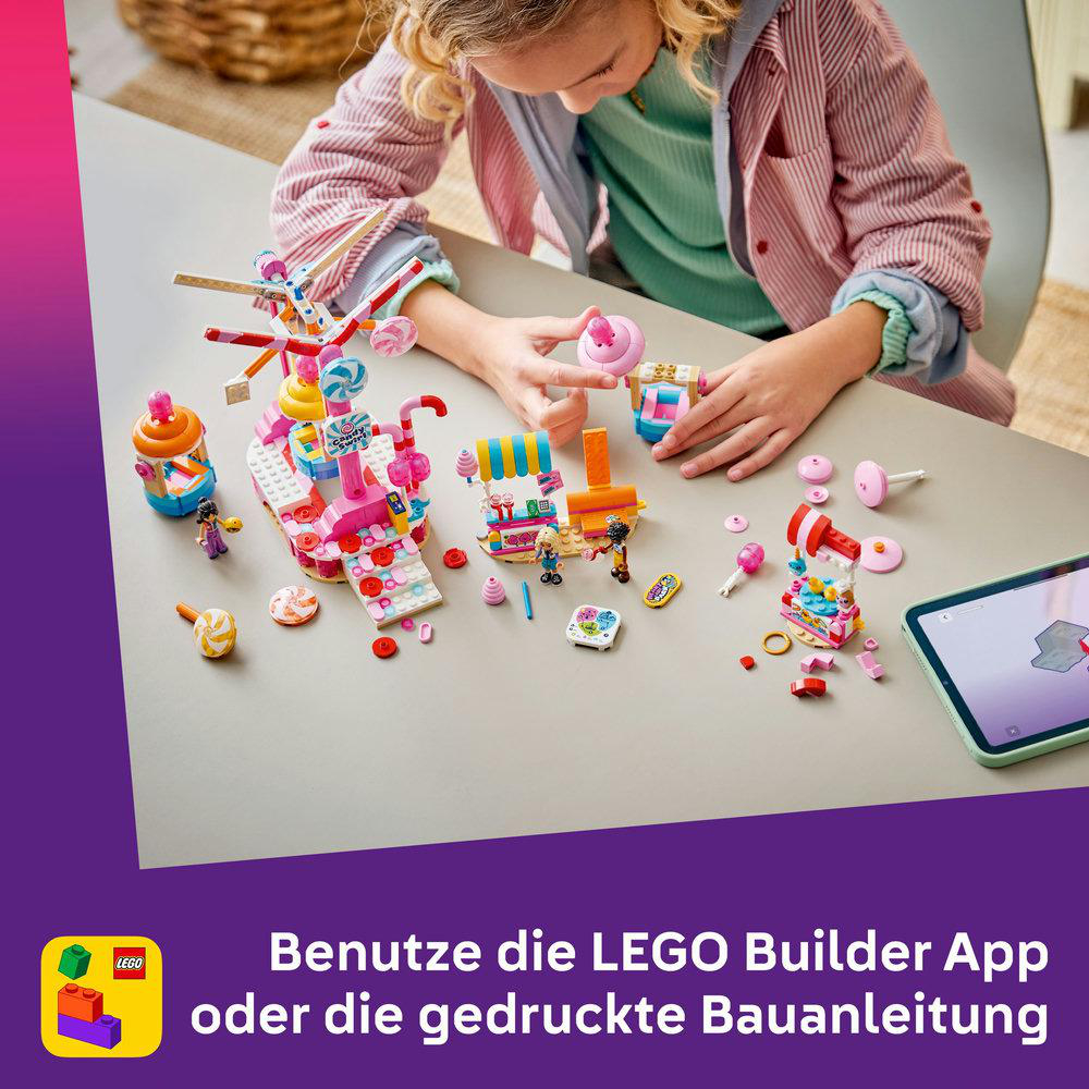 Ein Mädchen baut mit bunten Legosteinen einen Süßigkeiten-Themenpark auf einem Tisch.