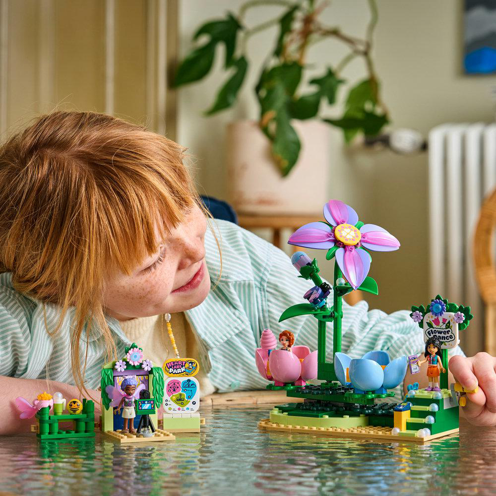 Ein Mädchen spielt mit einem bunten Lego-Blumenladen-Spielset.