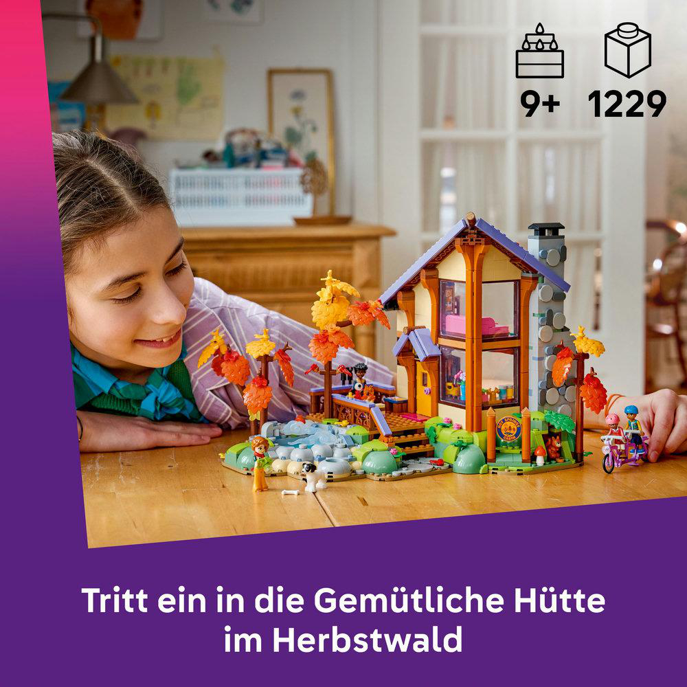 Mädchen blickt auf Lego-Herbsthütte mit Figuren und Tieren auf einem Holztisch.