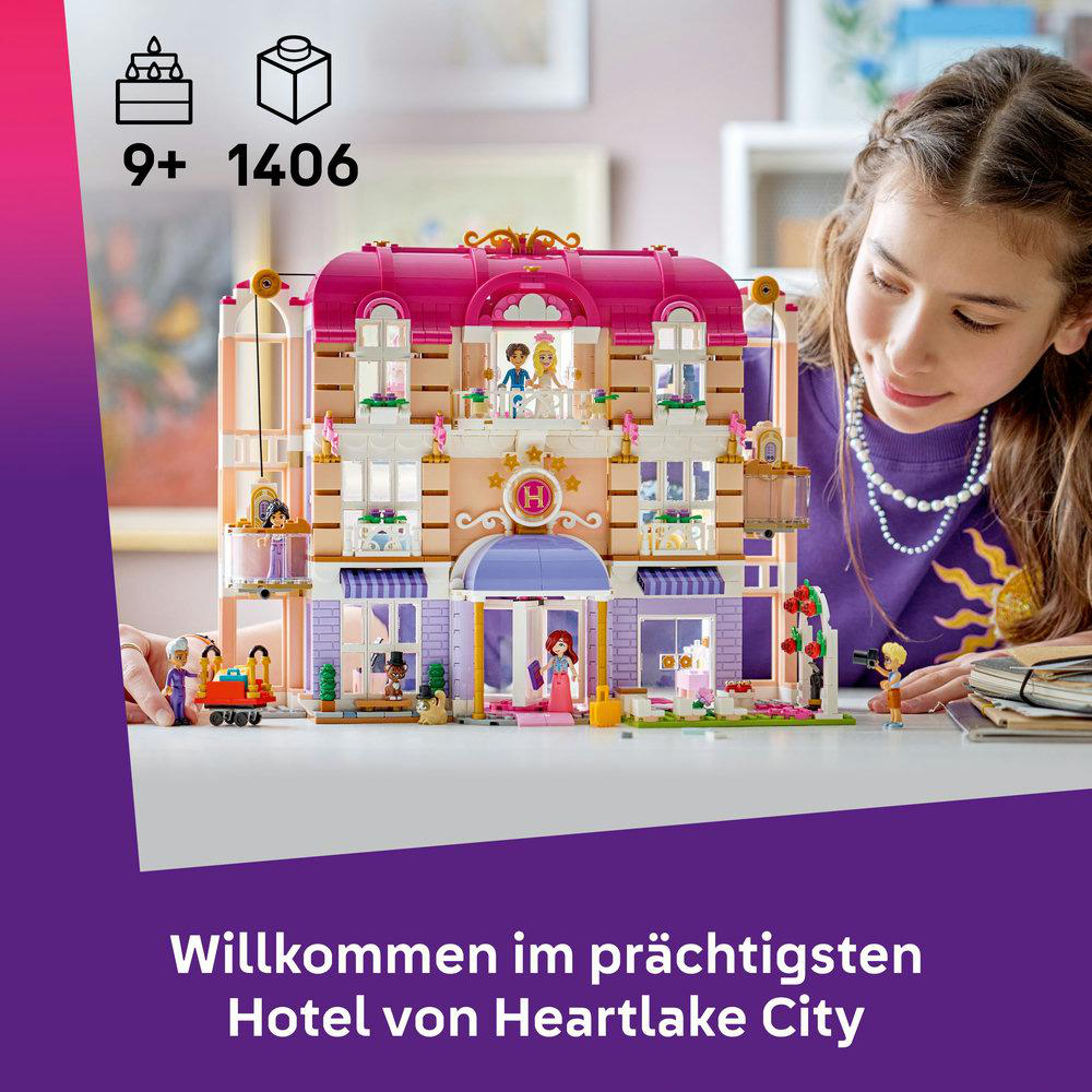 Ein Mädchen blickt auf ein detailliertes LEGO Hotel mit Figuren und vielen Fenstern.