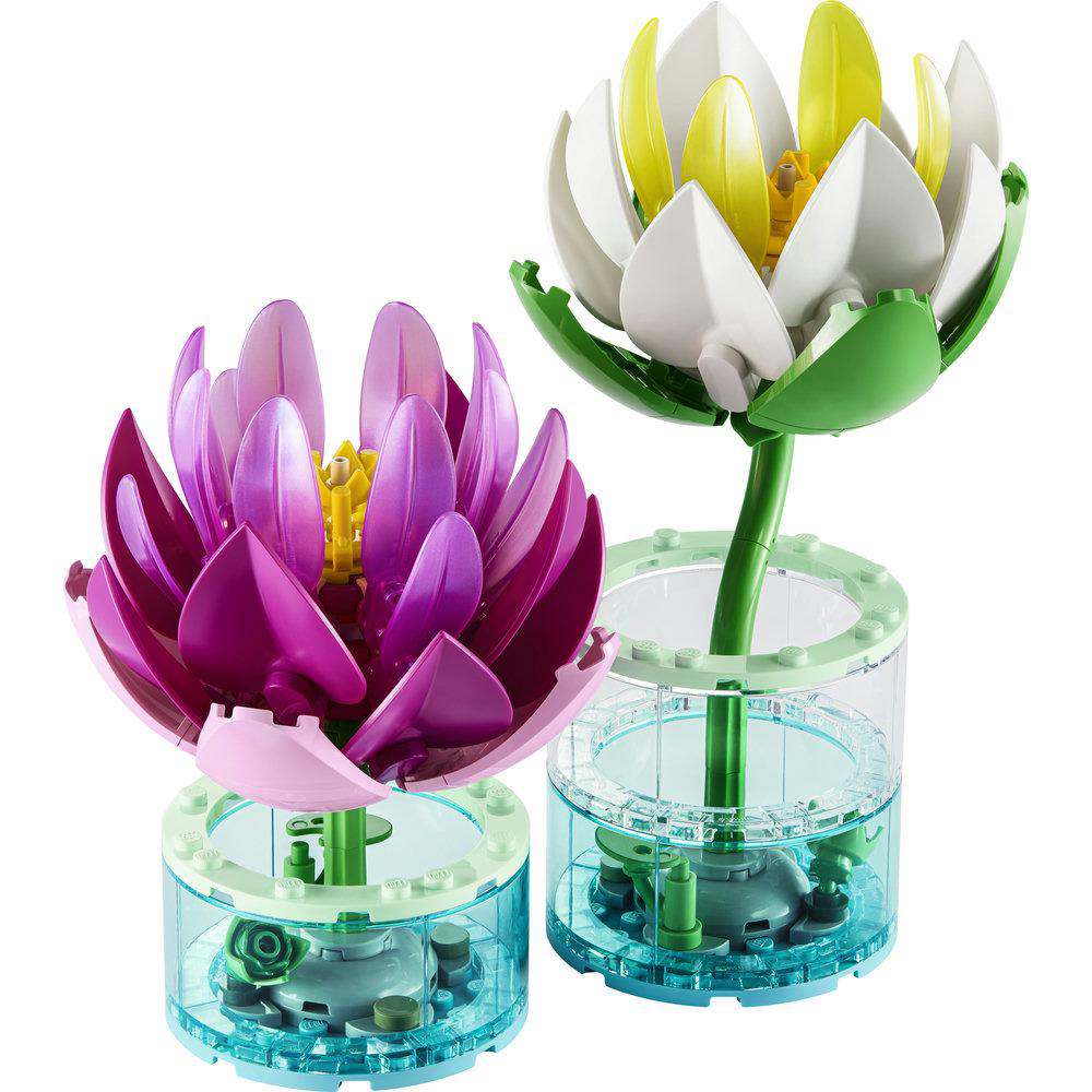 Zwei Lego-Lotusblumen in lila und weiß mit gelben Akzenten in durchsichtigen Behältern.