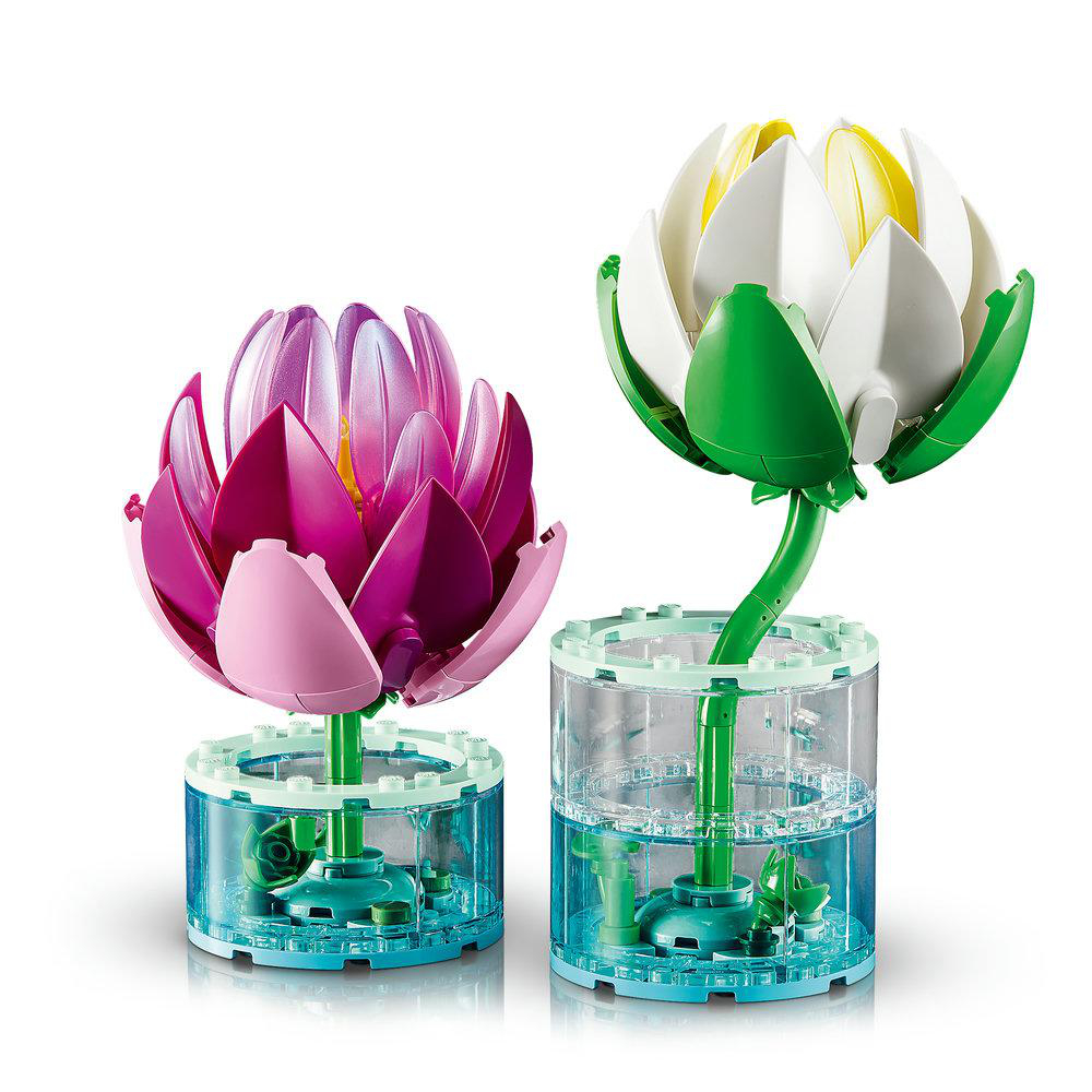 Zwei LEGO-Blumen: eine pinke und eine weiße, in durchsichtigen Behältern.