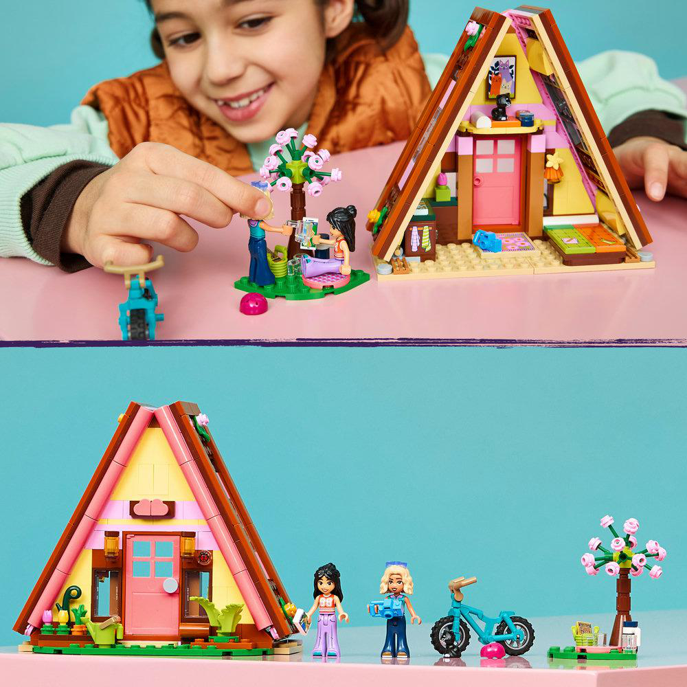 Ein Mädchen spielt mit Lego-Häusern, Figuren und einem Fahrrad.