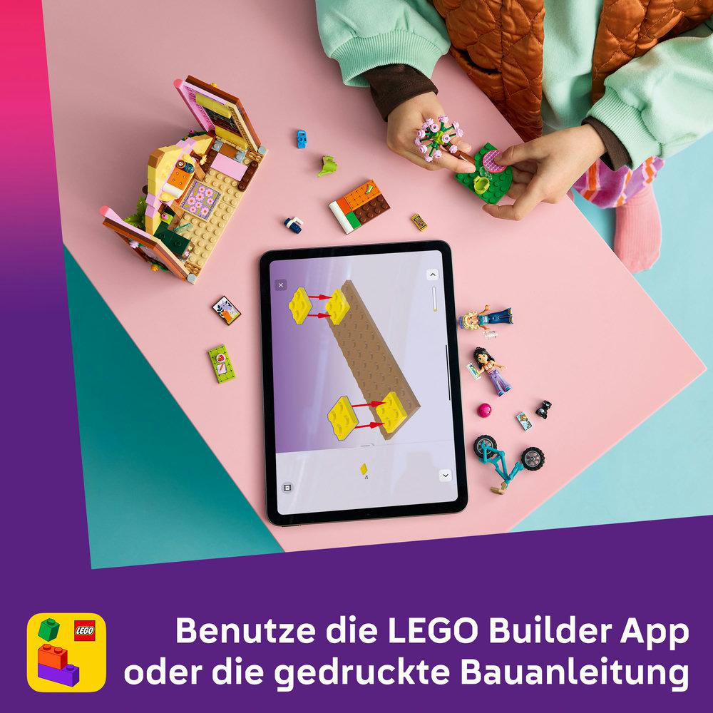 Personen bauen mit LEGO-Steinen und Tablet-Anleitung. Viele bunte Teile.