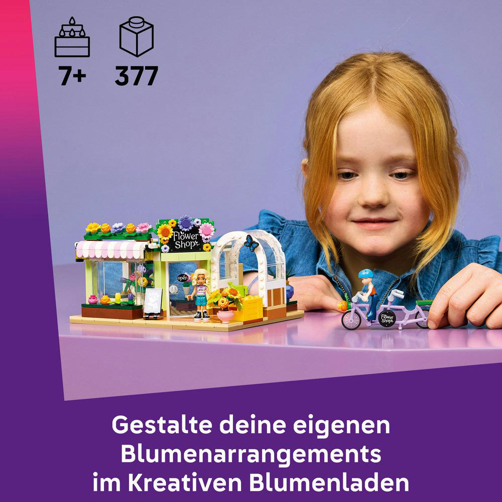 Ein Mädchen schaut auf ein Lego-Blumenladen-Set mit einer Figur und einem Fahrrad.