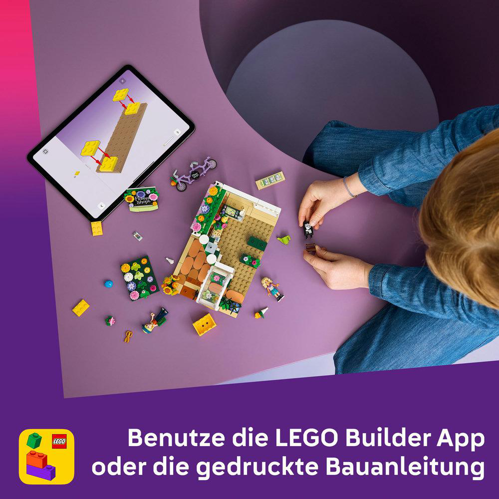Ein Kind baut mit LEGO-Steinen, eine Anleitung auf dem Tablet ist zu sehen.