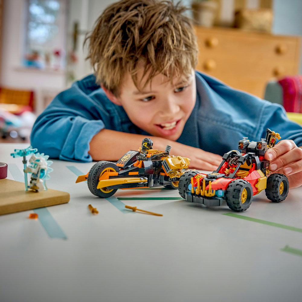 Ein Junge spielt mit Lego-Fahrzeugen: einem Motorrad und einem Buggy.
