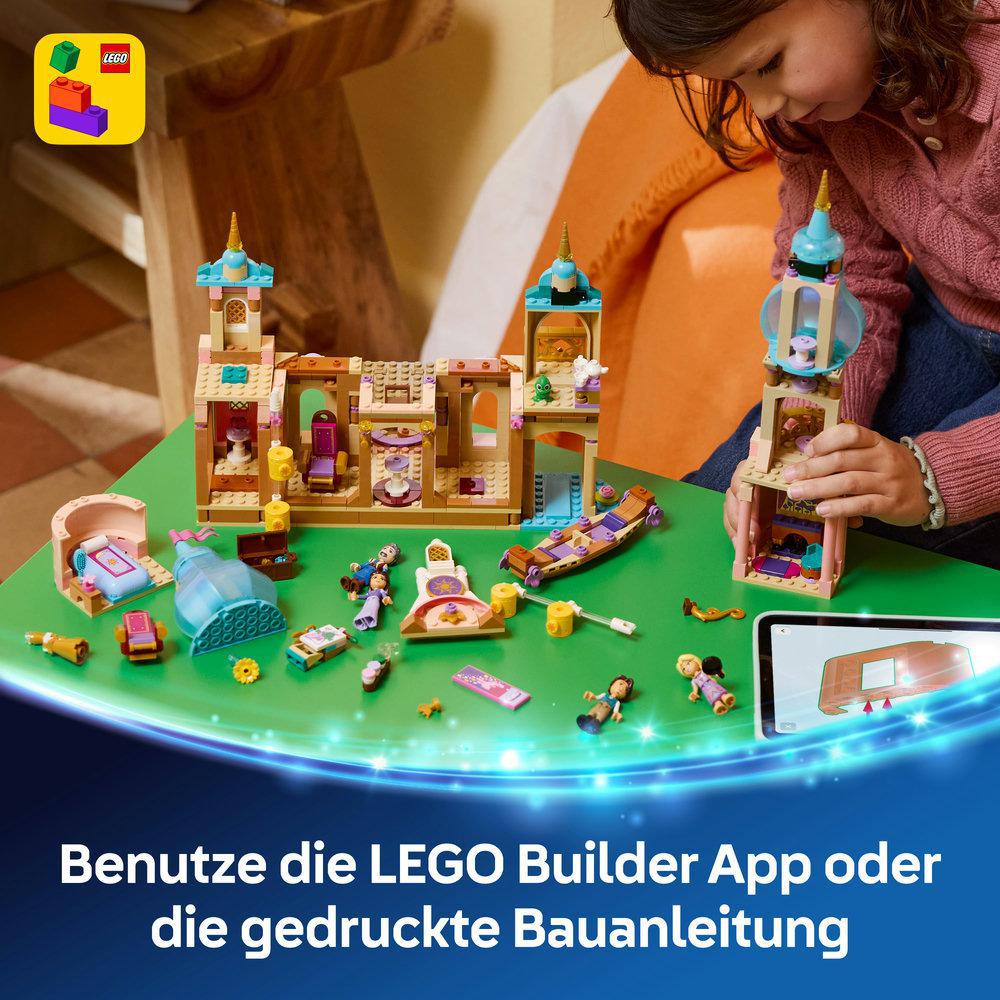 Ein Kind baut mit bunten LEGO-Steinen eine Burg. Viele kleine Figuren und Möbel sind ausgelegt.