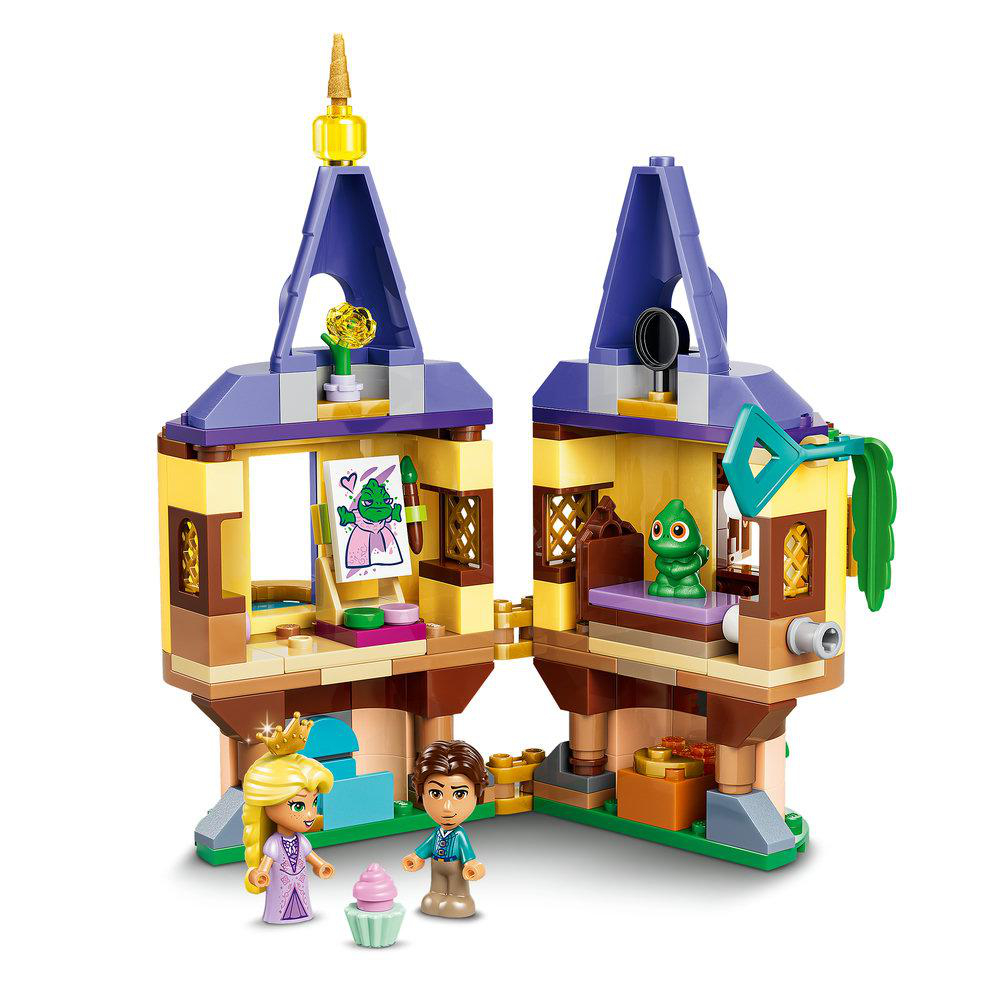 Ein lila und gelbes Modell eines Schlosses mit Figuren und einem grünen Baby-Dinosaurier.