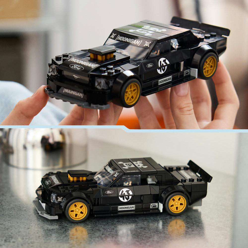 Schwarzes Lego-Rennauto mit gelben Felgen und Hoonigan-Aufklebern.