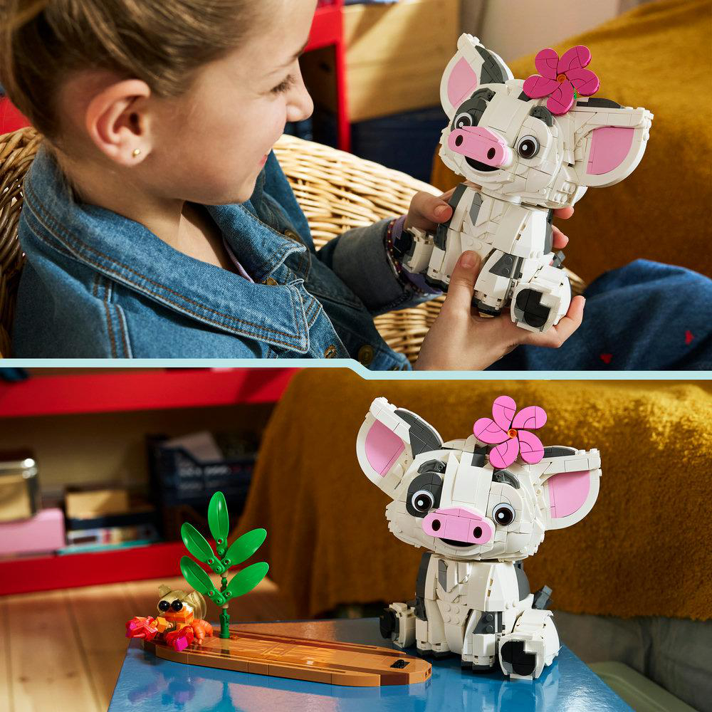 Ein Mädchen hält ein Lego-Schweinespielzeug. Das Spielzeug ist weiß mit schwarzen Flecken und einer rosa Blume.