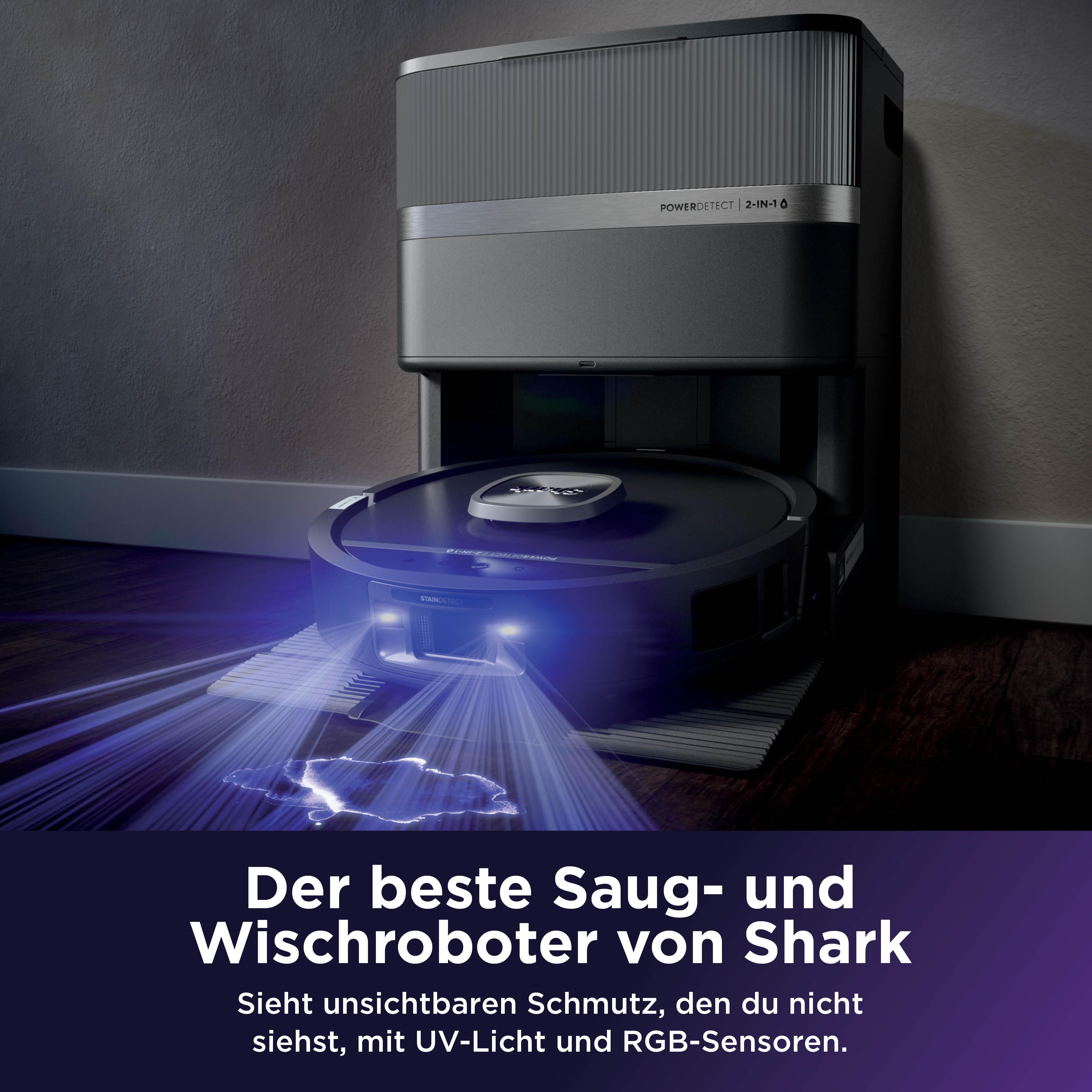 Ein schwarzer Shark Saugroboter dockt an seiner Basis an und sendet blaues Licht aus, das Schmutz enthüllt.