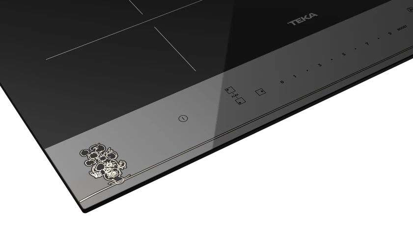Una placa de inducción negra con controles táctiles y un emblema de Mickey Mouse.