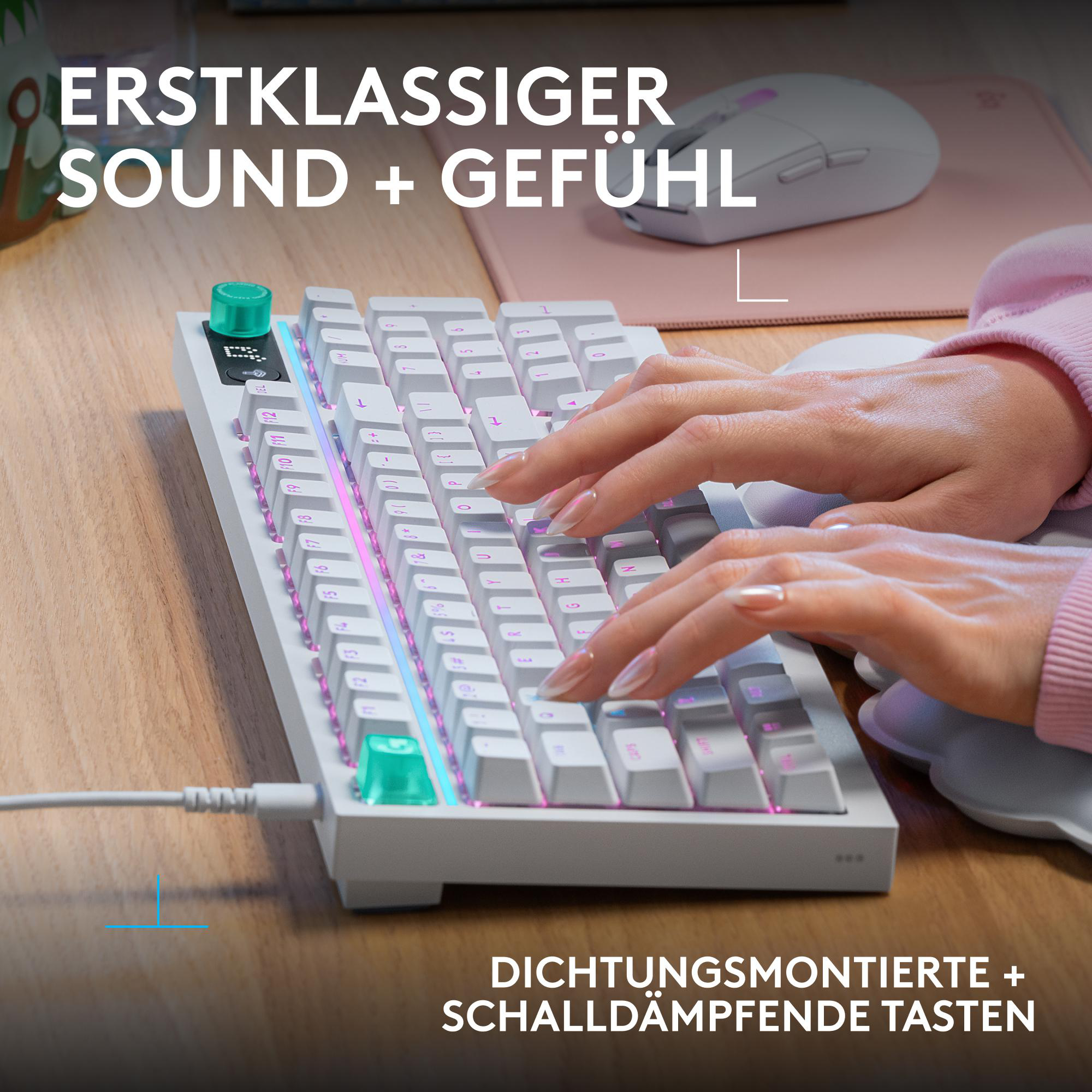 Hände tippen auf einer weißen Tastatur mit RGB-Beleuchtung, Maus im Hintergrund.