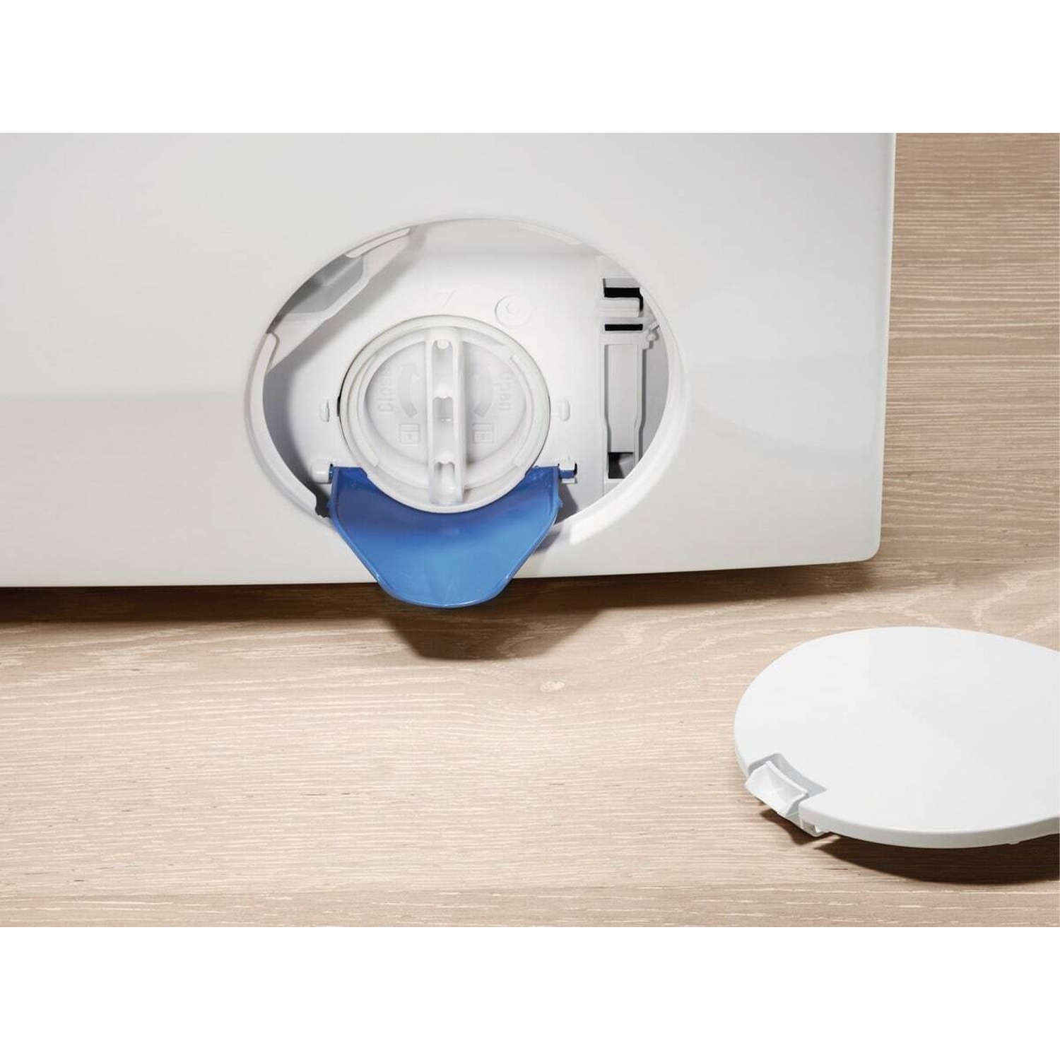 Un filtro bianco per lavatrice con manico blu e coperchio rimosso.