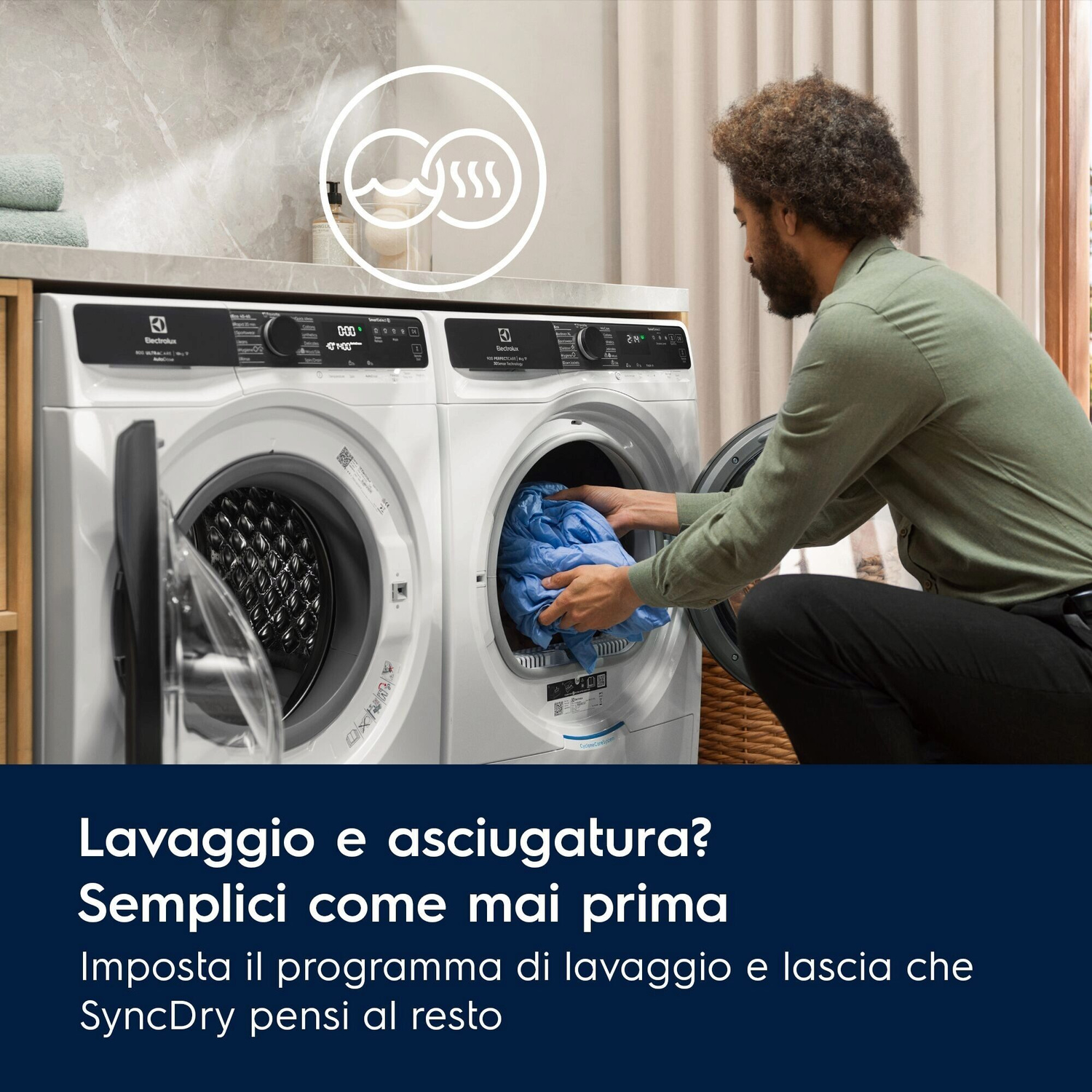 Uomo carica un'asciugatrice con vestiti blu accanto a una lavatrice.