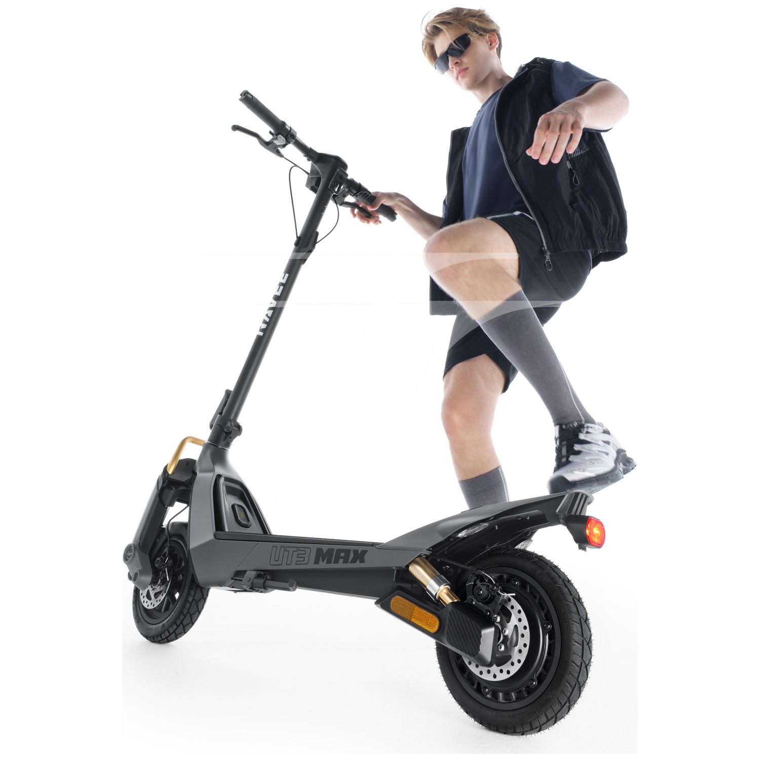 A man in sunglasses stands on a gray e-scooter labeled "UTB MAX".
